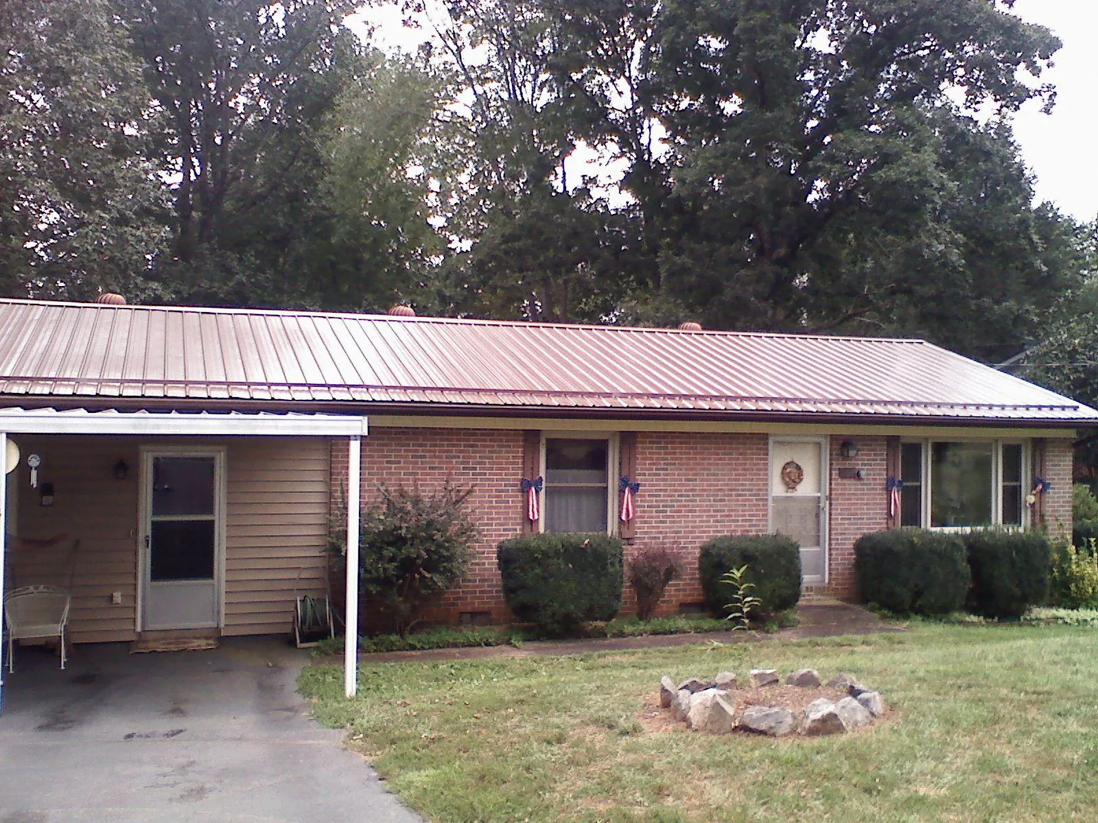 Bronze metal roof and carport on a brick ranch home — Roof Repair work by our crew in Amanda Park