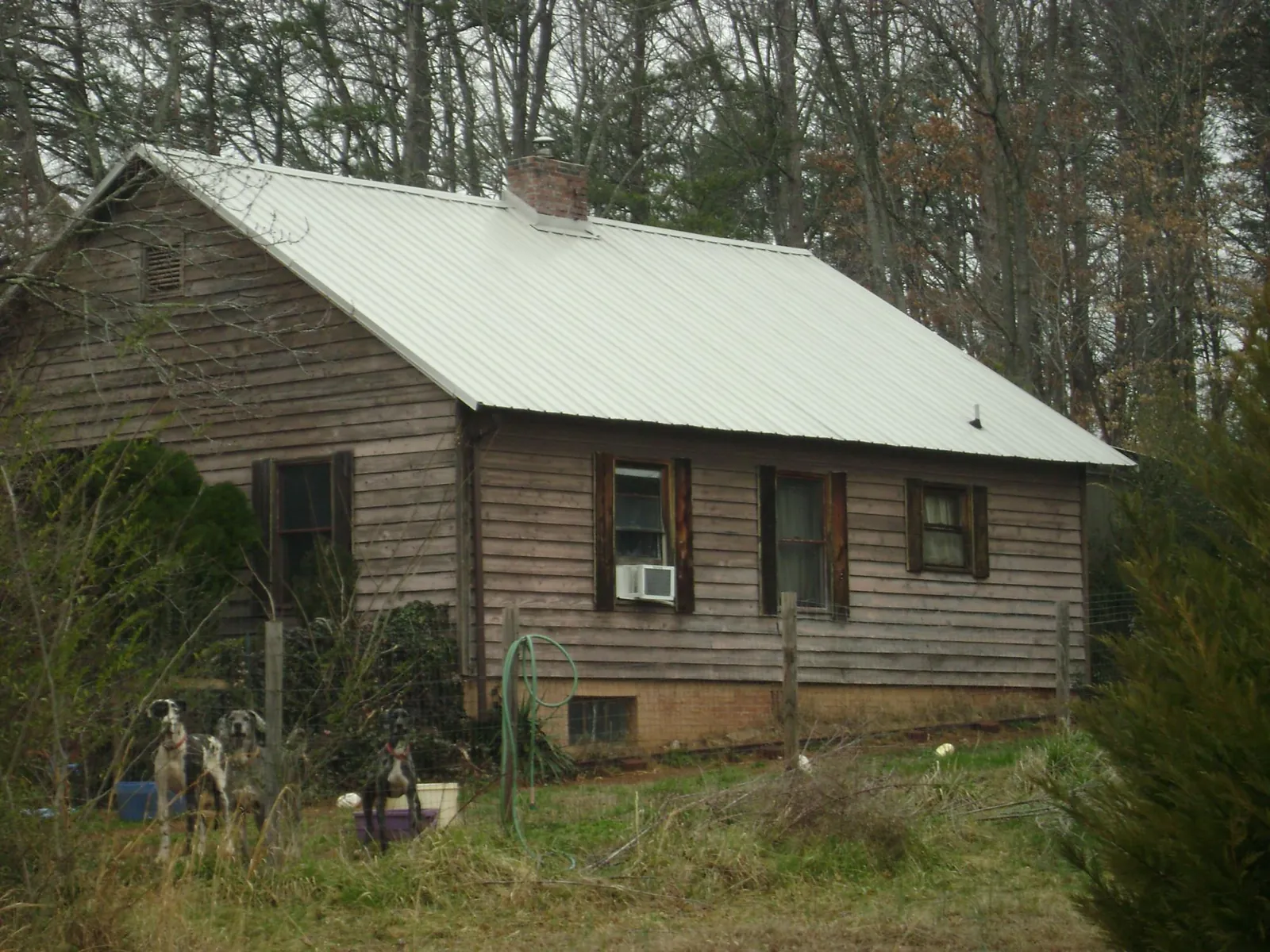 White metal roof on an old wood sided farmhouse, from a Metal Roof Installation job in Amanda Park